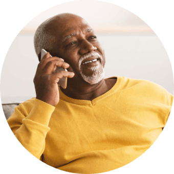 Man in a yellow shirt talking on the phone, headshot