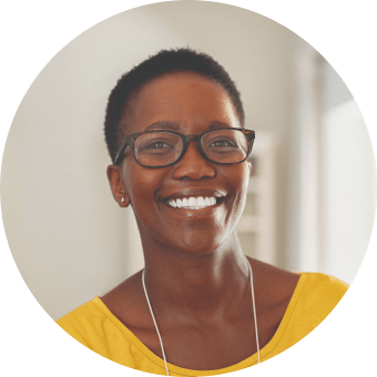 Woman with glasses and yellow shirt smiling, headshot