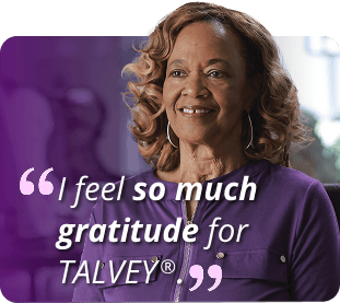 Gail, a real patient, wearing a purple shirt and smiling